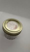 Petal Burst candle in a textured glass jar with a gold-tone lid and floral label
